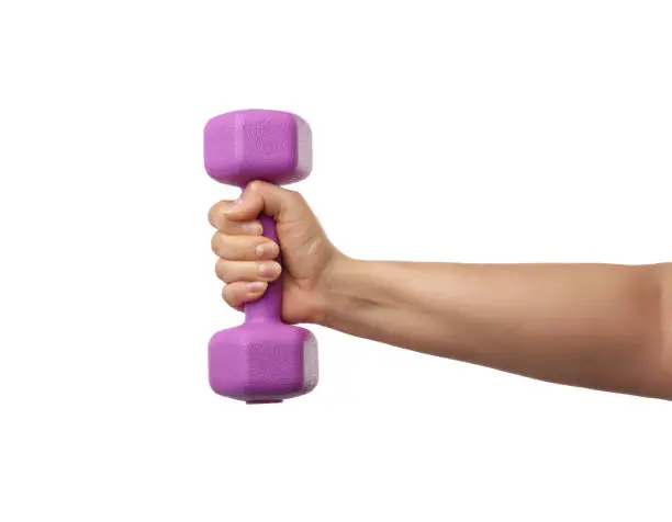 female hand holds a plastic pink dumbbell on a white isolated background, sport concept