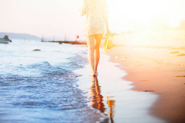 Alone depressive young woman walking on the beach