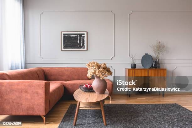 Retro Wooden Cabinet With Black Vases In The Corner Of Classy Grey Living Room Interior With Ginger Sofa Stock Photo - Download Image Now