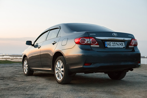 Oleksandrivka, Dnipropetrovsk region, Ukraine - march 10, 2020: Toyota Corolla gray color on the Samara river bank in twilight