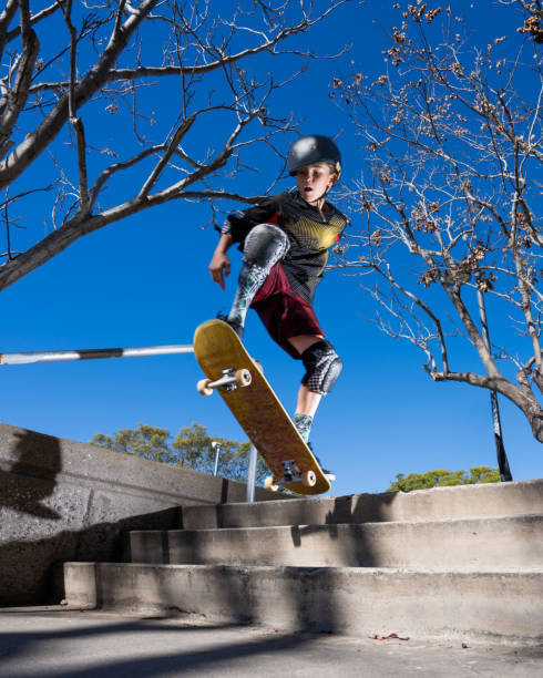 young boy im skatepark - extreme skateboarding action balance motion stock-fotos und bilder