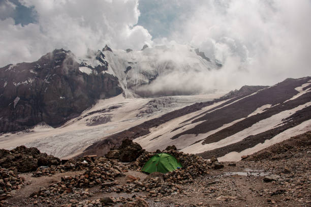 istock Tourist tent standing among rocks in mountains 1212049688