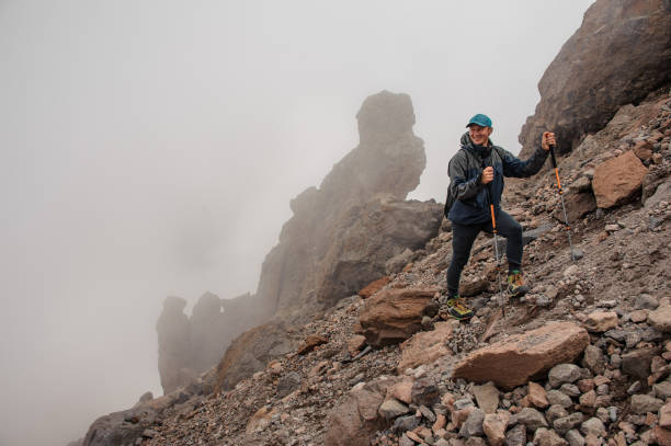 istock Smiling trekker stands on a mountain side 1212049982