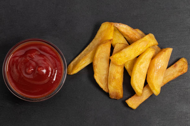 istock French fries with ketchup on dark table, top view 1212052805