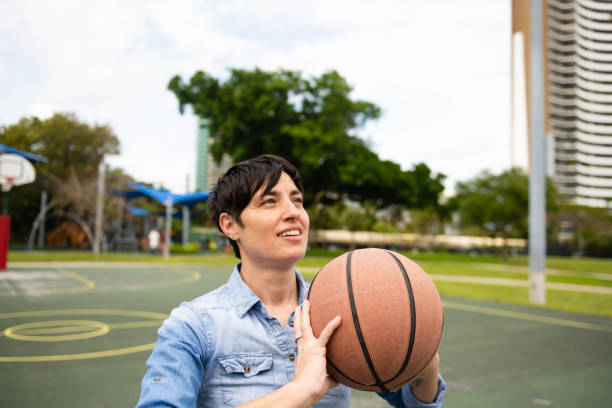 masculino género no conforme persona jugando baloncesto en el parque - miami basketball fotografías e imágenes de stock