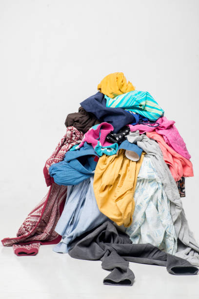 istock pile of used clothes on a light background. Second hand for recycling 1212053707