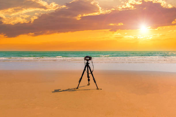 cyfrowy profesjonalny aparat stoi na statywie fotografowania morza. zmierzch niebo tło. kolorowe niebo zachód słońca i cloud.vivid niebo w tle zmierzchu czasu. ognisty pomarańczowy zachód słońca niebo. piękny - 11244 zdjęcia i obrazy z banku zdjęć