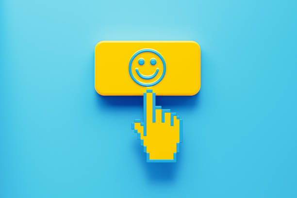 Hand Shaped Computer Cursor Clicking over A Yellow Push Button: There is Smiley Face Icon on Push Button Hand shaped computer cursor clicking on a yellow computer button on blue background. There is smiley face icon on push button. Horizontal composition with copy space. Rating concept. cursor photos stock pictures, royalty-free photos & images
