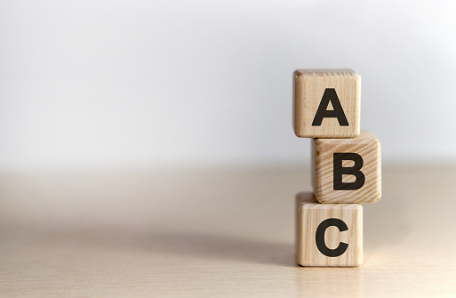 ABC - text on wooden cubes, on wooden background