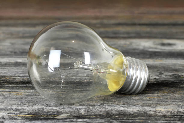 istock Light bulb on wooden background 1212057884