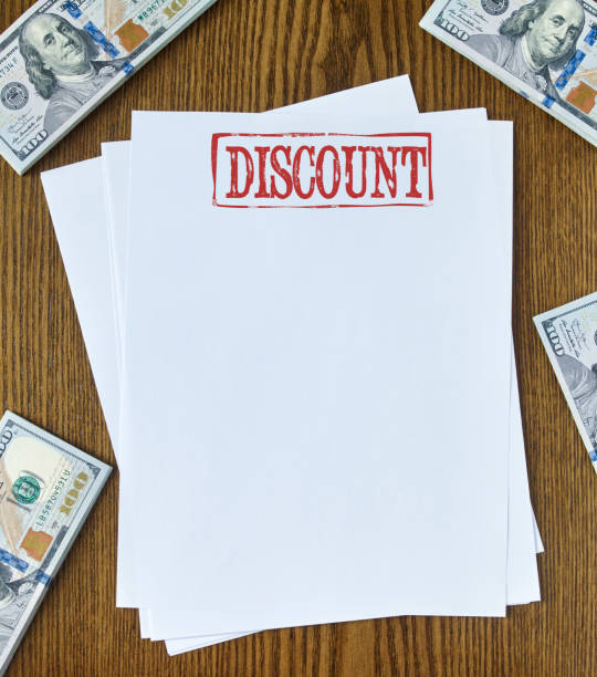 Discount Looking down on wooden desk with blank paper with “Discount” stamp 100 dollar bills one hundred dollar stamp stock pictures, royalty-free photos & images
