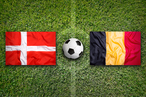 Denmark vs. Belgium flags on green soccer field