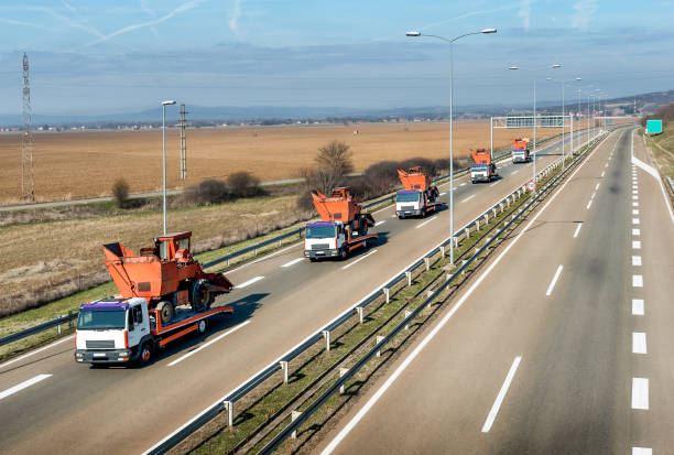 istock Tow trucks or Flatbed trucks towing agricultural or construction machines 1212061882