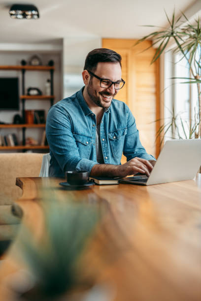 istock Happy handsome man using laptop at wooden table, portrait. 1212062401