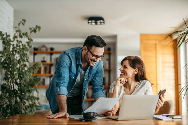 istock Smiling couple looking at documents at home office, portrait. 1212062407