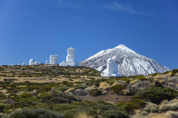 Teide Observatory Astronomical telescopes and Pico de Teide with a snow cap Pico De Teide, Spain - 25th November, 2014: Teide Observatory Astronomical telescopes and Pico De Teide volcano with a snow cap. This volcano is the highest mountain in Spain. observatory tenerife canary islands el teide national park stock pictures, royalty-free photos & images