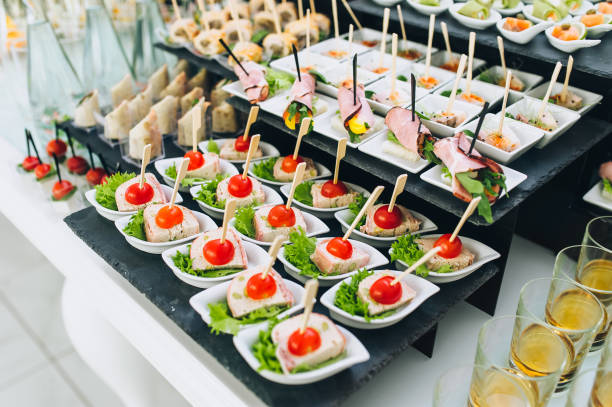istock Buffet reception of different delicious food at a wedding celebration. Snacks for guests. Wedding party. Canapes, sushi, fruit, meat, drink, wine, juice. 1212065328