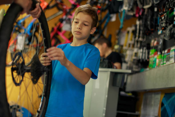 istock Young boy fixing the spokes of a bicycle tire 1212068594