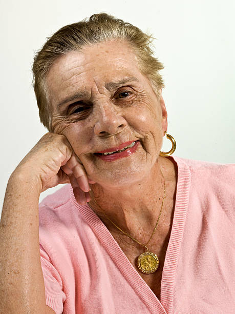 Senior woman with beautiful eyes on grey background, closeup