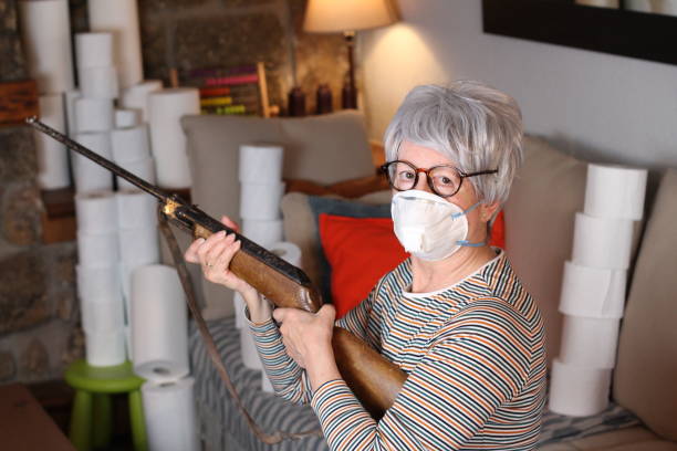 Senior woman holding weapon during quarantine Senior woman holding weapon during quarantine. old guns stock pictures, royalty-free photos & images