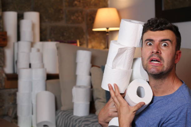 Man stocking up toilet paper at home Man stocking up toilet paper at home. hysteria stock pictures, royalty-free photos & images
