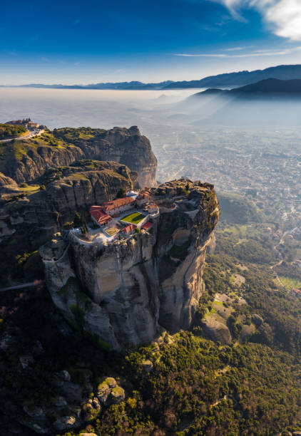 vista aerea del monastero trinità e immagini mozzafiato della valle e canyon di meteora al tramonto, kalambaka, grecia, ombre, strada contorta, ponte, montagne come colonne - meteora monk monastery greece foto e immagini stock