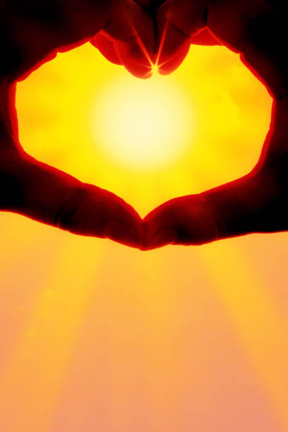 istock Hands forming a heart shape over the sun 1212073239