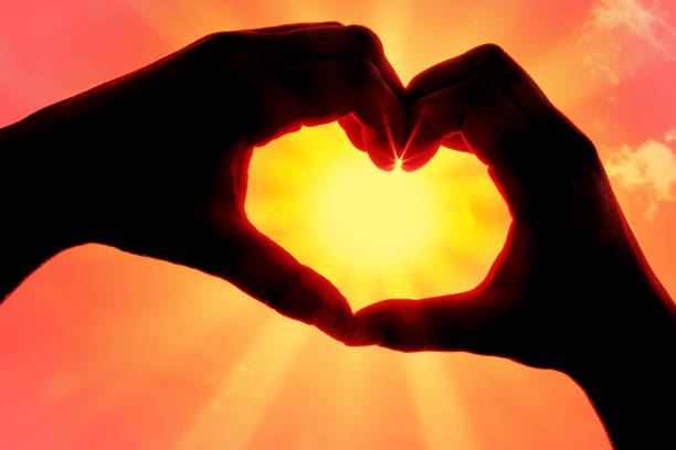 istock Hands forming a heart shape over the sun 1212073258