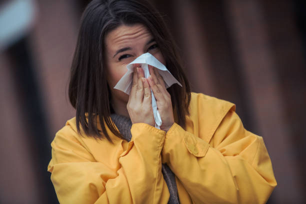 istock Sick young woman blowing her nose 1212076552