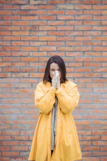 istock Sick young woman blowing her nose 1212077041