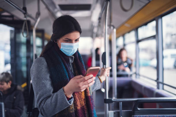 istock Young Woman With Face Mask Using Phone. 1212077116