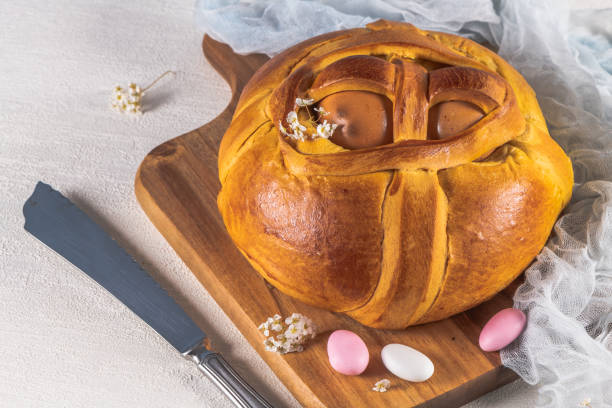 istock Portuguese traditional Easter cake. Folar with eggs on wooden table 1212077532
