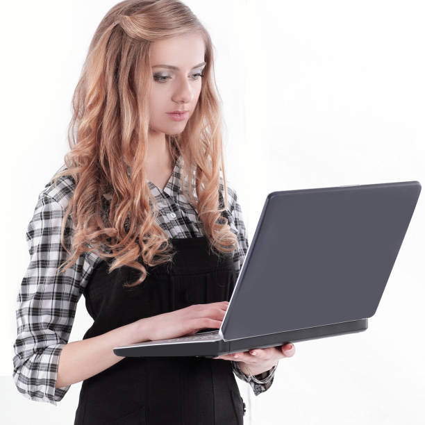 istock young business woman standing with an open laptop. 1212085672