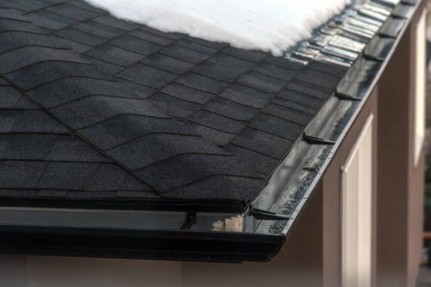 istock Snow melting on shingled roof with eavestrough 1212087097