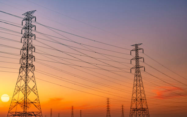 istock Silhouette high voltage electric pylon and electrical wire with purple and red sunset sky. Electricity poles at sunset. Power and energy concept. High voltage grid tower with wire cable. Steel pylons. 1212088746