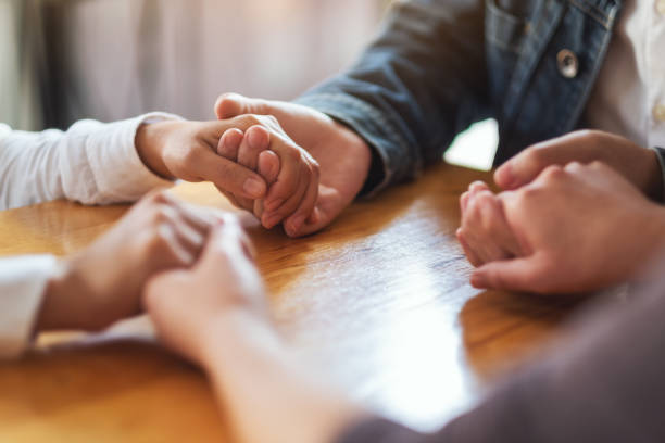 istock people sitting in a circle holding hands and pray together or in therapy session 1212091310