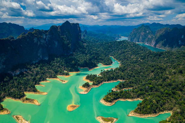 Aerial drone view looking down onto tiny, jungle covered islands in a huge lake surrounded by limestone cliffs. (Cheow Lan Lake, Khao Sok) Aerial drone view looking down onto tiny, jungle covered islands in a huge lake surrounded by limestone cliffs. (Cheow Lan Lake, Khao Sok) kao sok national park stock pictures, royalty-free photos & images