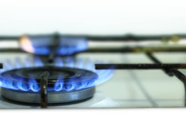 Close-up image of a gas stove burner actively emitting a ring of blue flames, indicating complete combustion and optimal energy efficiency. The vibrant blue color signifies clean burning with minimal carbon monoxide output, making it a reliable and eco-friendly heating source. This concept is ideal for illustrating themes of sustainable energy, alternative heating solutions, and cost-effective cooking or warming methods in households. Suitable for topics related to clean energy, rising electricity costs, off-grid living, eco-conscious kitchen appliances, and modern gas-powered heating systems. Can be used in articles, blogs, and campaigns promoting energy efficiency, sustainable living, and environmentally responsible home solutions.