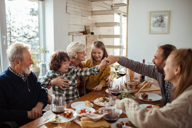 Family Meal during the Holidays Close up of a multi generational family having a big meal during the winter holidays multi generation family christmas stock pictures, royalty-free photos & images