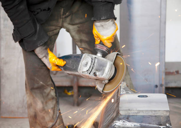 Heavy industry worker cutting steel with an angle grinder. Electric grinder.