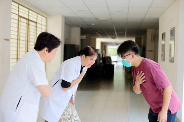 A young man placed his right palm on his left chest with half bow posture to two female adults as a gesture of greetings (Malaysian culture).