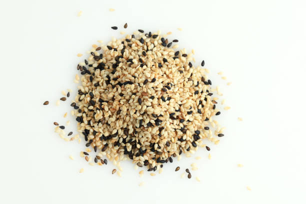 ansicht von oben haufen aus weißem und schwarzem sesam isoliert auf weißem hintergrund. - white sesame seed stock-fotos und bilder