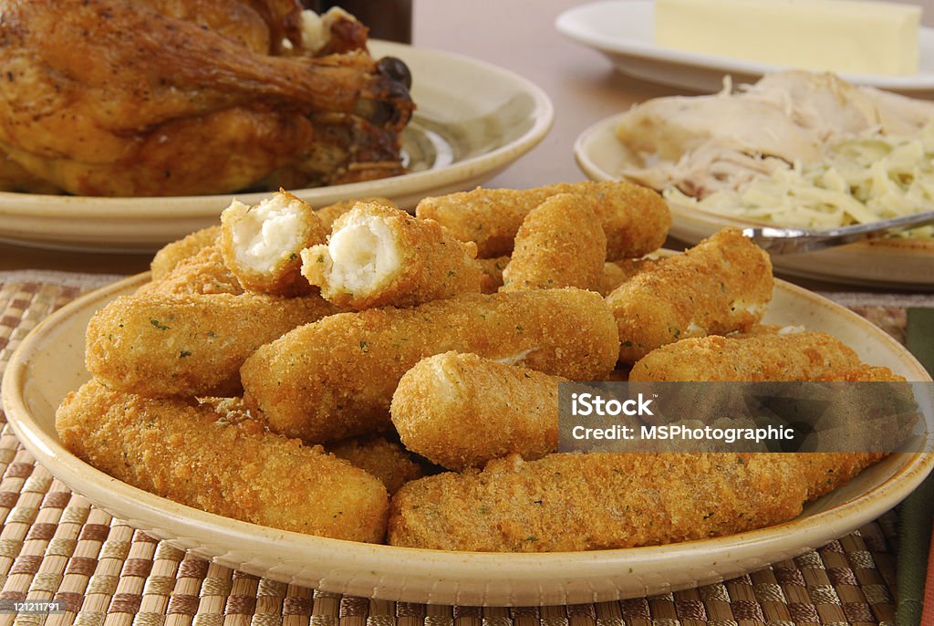 Breaded cheese sticks on a plate with table of food A plate of breaded mozzarella cheese sticks Stick - Plant Part Stock Photo