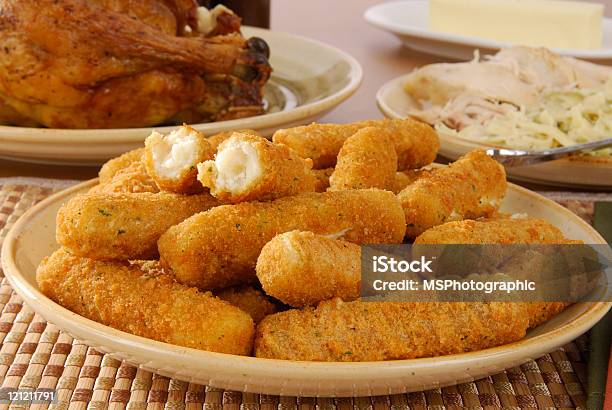 Breaded Cheese Sticks On A Plate With Table Of Food Stock Photo - Download Image Now