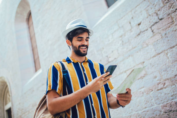 istock Handsome bearded tourist with backpack is making travel across city, using phone. 1212119007