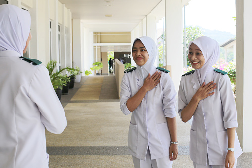 A group of people giving greetings alternative to handshakes by place right palm on left chest.