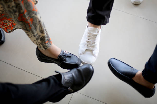 A group of friends giving greetings alternative to handshakes by group tapping their shoes.