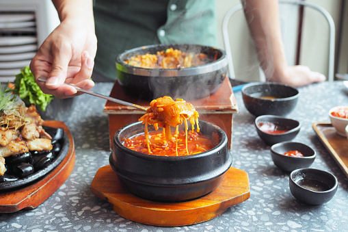Kimchi soup served in hot pot; traditional Korean food. Selective focus.