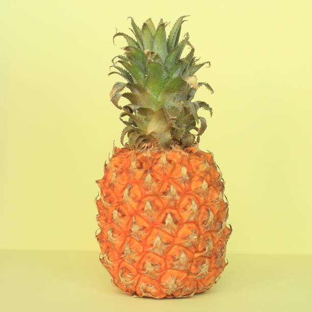 istock ripe pineapple on a yellow background.photo with copy space 1212129590
