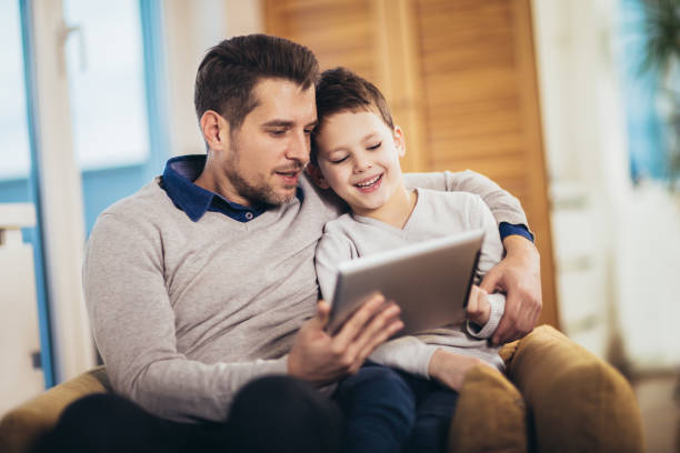 istock Father and son playing on a tablet at home, having fun 1212132389